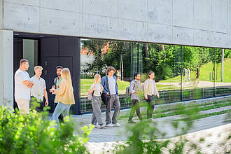 Mehrere Gruppen von Studierenden, unterhalten sich auf dem Vorplatz des Aula- / Hörsaalgebäudes. Mehrere Gruppen von Studierenden, unterhalten sich auf dem Vorplatz des Aula- / Hörsaalgebäudes.