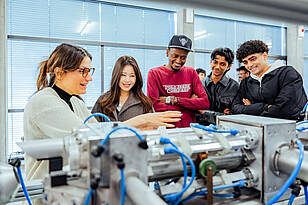 titelbild-mechanical_engineering Studierende aus dem Bachelorstudiengang Mechanical Engineering schauen sich ein Maschinenteil an