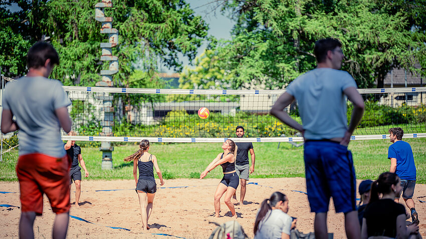 Studierende spielen auf dem Beachvolleyballfeld der Beethovenstraße Volleyball. Studierende spielen auf dem Beachvolleyballfeld der Beethovenstraße Volleyball.