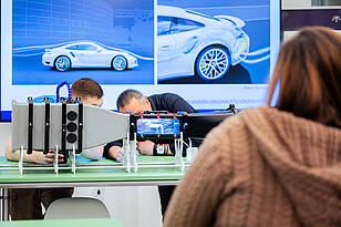 Titelbild-Allgemeiner_Maschinenbau Zwei Studierende und ein Professor, des Bachelorstudiengangs Allgemeiner Maschinenbau arbeiten an einem Modell