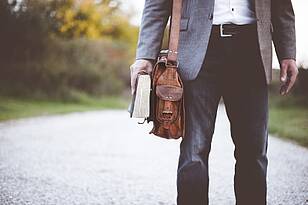 HL-Titelbild Lehrer mit einer Tasche und einem Buch in der Hand