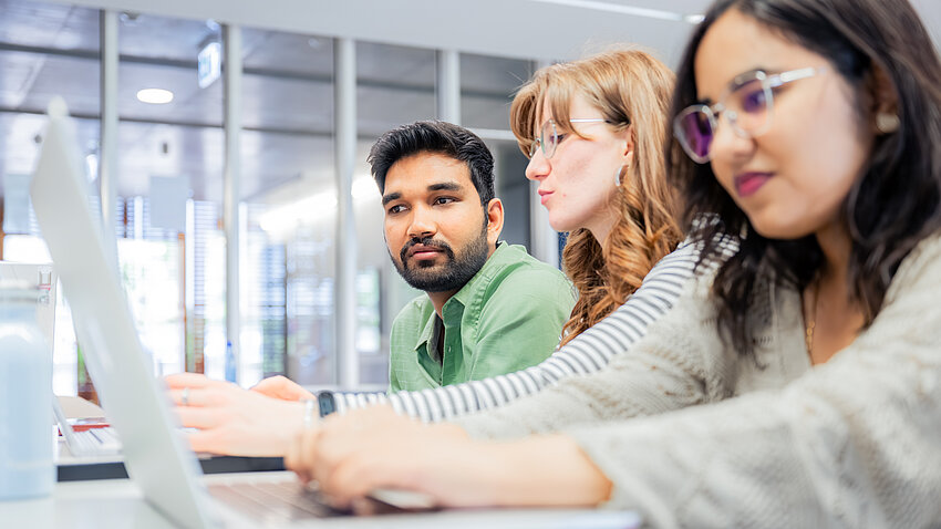 Drei Studierende arbeiten gemeinsam am Computer. Drei Studierende arbeiten gemeinsam am Computer.
