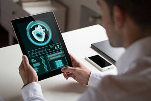 HTM-Titelbild Ein Student aus dem Masterstudiengang Health Technology Management arbeitet an einem Tablet.